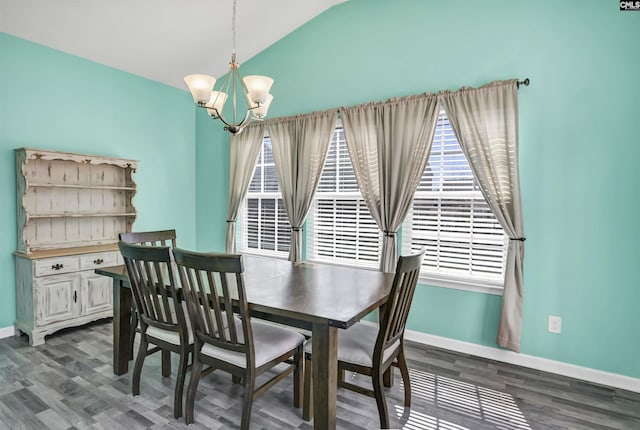 dining area featuring a notable chandelier, dark wood-style flooring, baseboards, and vaulted ceiling