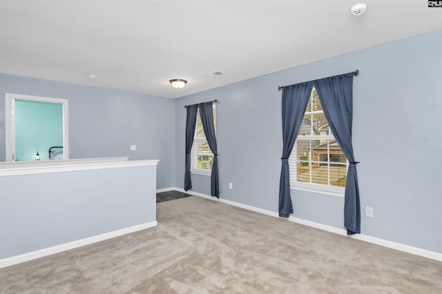 empty room with visible vents, baseboards, and carpet floors