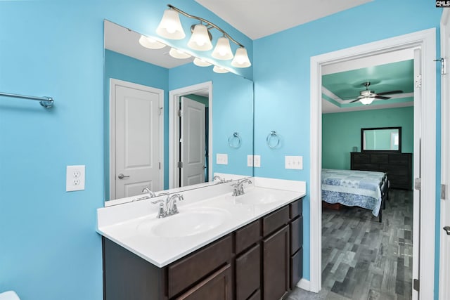 full bathroom with double vanity, wood finished floors, ensuite bathroom, and a sink