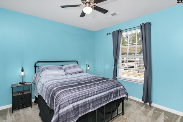 carpeted bedroom with visible vents, baseboards, and ceiling fan