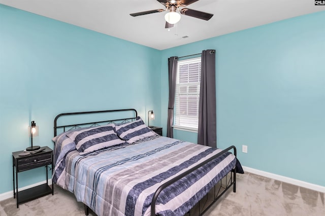 bedroom with visible vents, baseboards, light colored carpet, and a ceiling fan