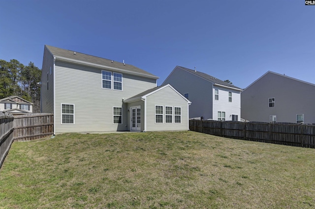 back of property with a lawn and a fenced backyard