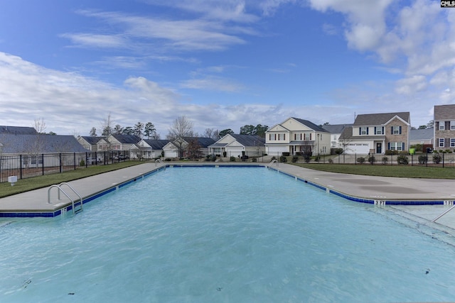 community pool featuring a residential view and fence