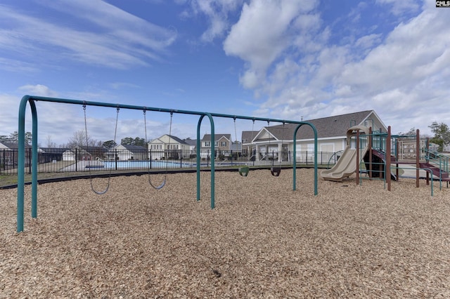 communal playground featuring fence and a residential view