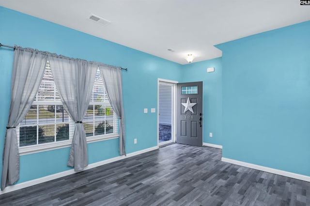 empty room with visible vents, baseboards, and wood finished floors