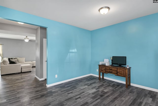 office with dark wood finished floors, a ceiling fan, and baseboards