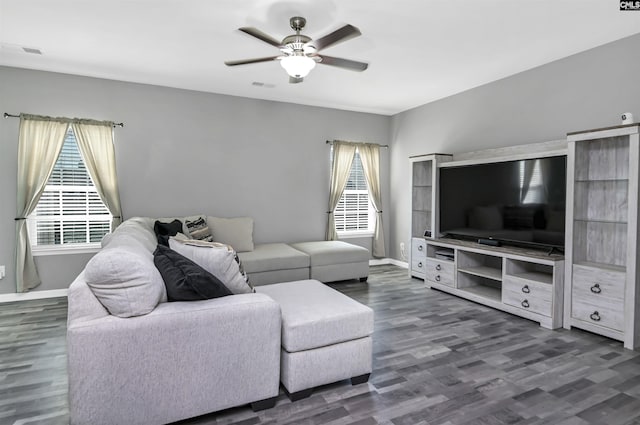 living area featuring baseboards, wood finished floors, visible vents, and ceiling fan