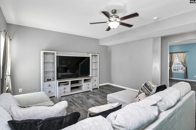 living room featuring dark wood-type flooring, baseboards, and ceiling fan