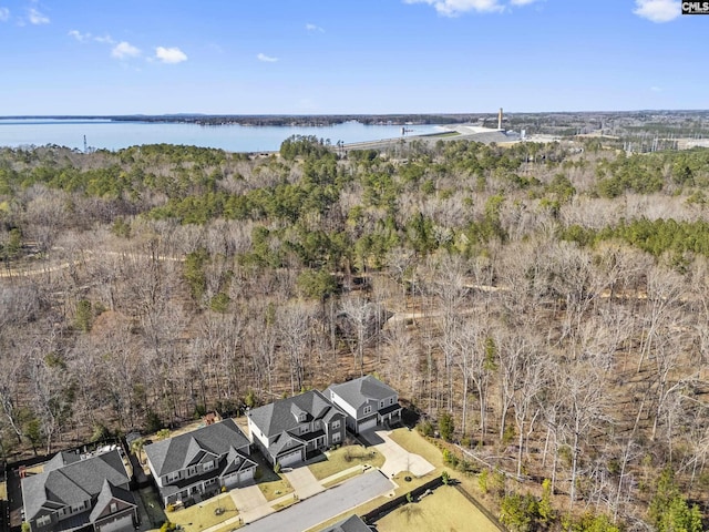 bird's eye view featuring a wooded view and a water view