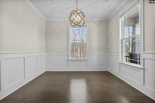 unfurnished dining area featuring a decorative wall, dark wood-type flooring, an inviting chandelier, and ornamental molding