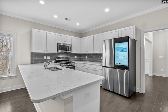 kitchen featuring visible vents, ornamental molding, a sink, appliances with stainless steel finishes, and a peninsula