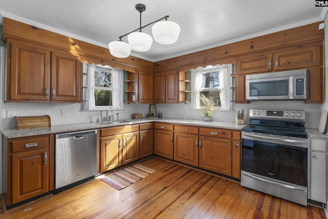 kitchen with brown cabinets, open shelves, a sink, light wood-style floors, and appliances with stainless steel finishes