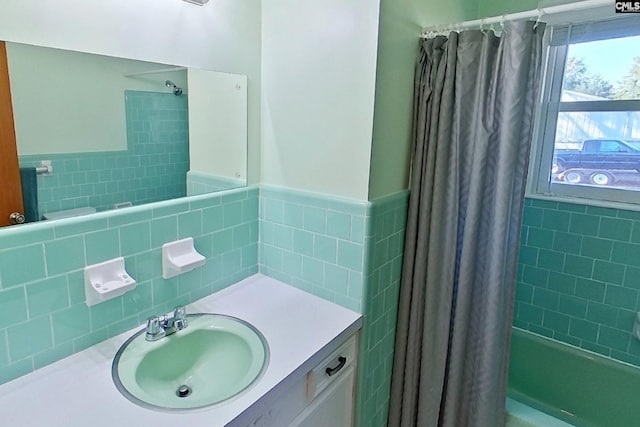 bathroom featuring vanity, tile walls, and shower / tub combo