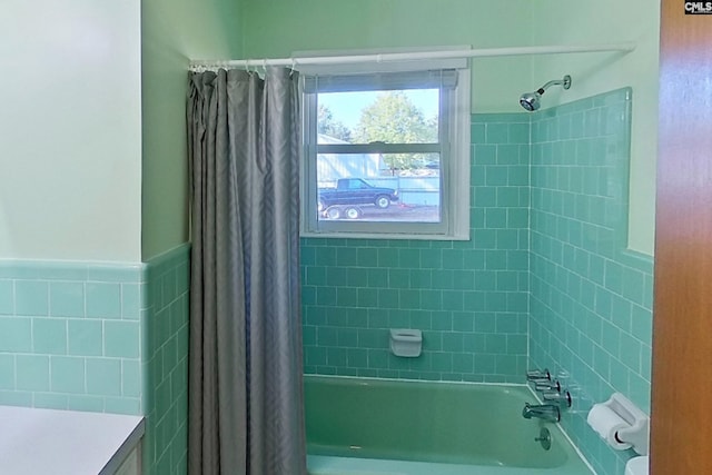 full bathroom with tile walls and shower / bath combo