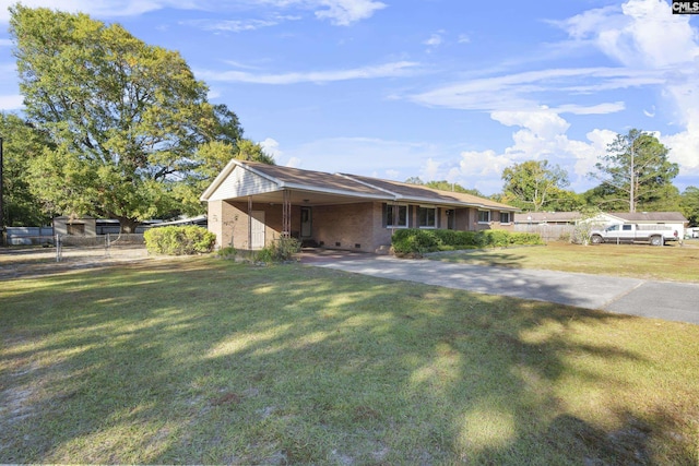 view of front of home featuring a front yard, fence, driveway, a carport, and brick siding