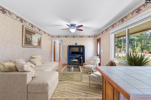 living room with light wood finished floors, wallpapered walls, and ceiling fan