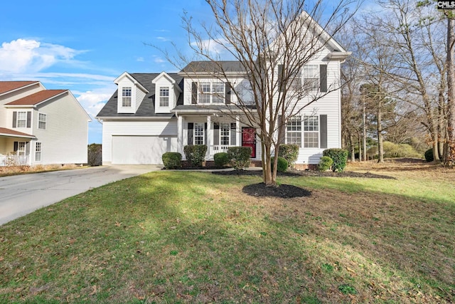 view of front of property featuring a front yard, covered porch, a garage, and driveway