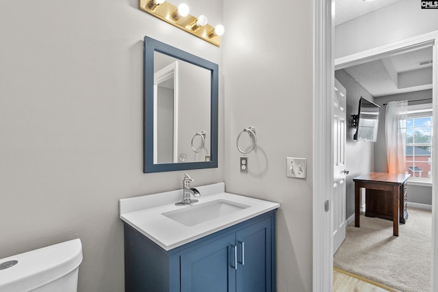 half bathroom with vanity, visible vents, baseboards, a textured ceiling, and toilet