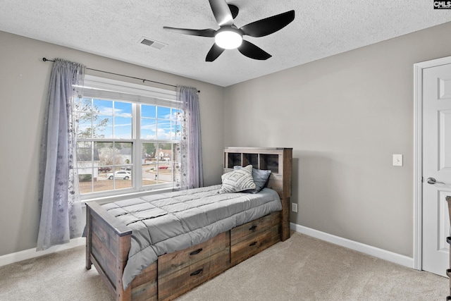 bedroom with carpet flooring, baseboards, visible vents, and a textured ceiling