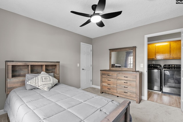 bedroom with washing machine and clothes dryer, a textured ceiling, light carpet, and a ceiling fan