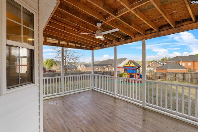 wooden terrace featuring a residential view, a lawn, a playground, and a fenced backyard