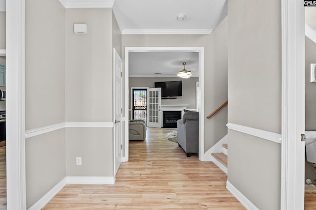 corridor with stairs, crown molding, baseboards, and wood finished floors