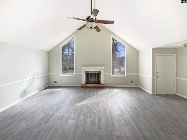 unfurnished living room featuring visible vents, a brick fireplace, ceiling fan, lofted ceiling, and wood finished floors