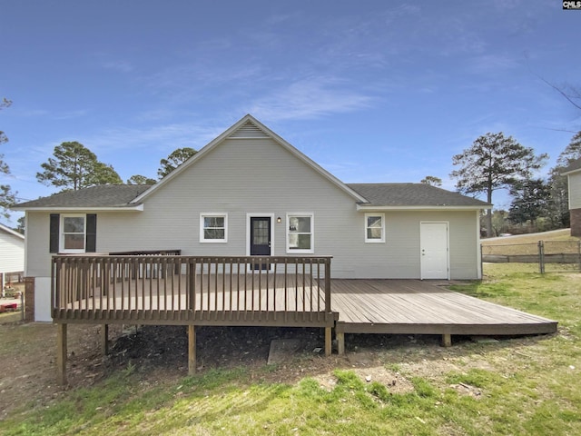 back of house featuring a wooden deck, roof with shingles, and fence