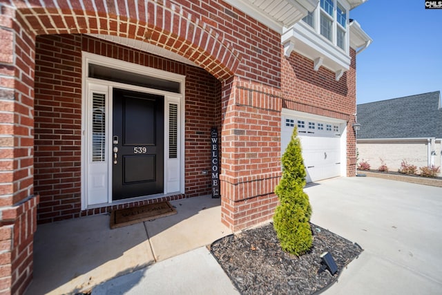 entrance to property featuring brick siding and driveway