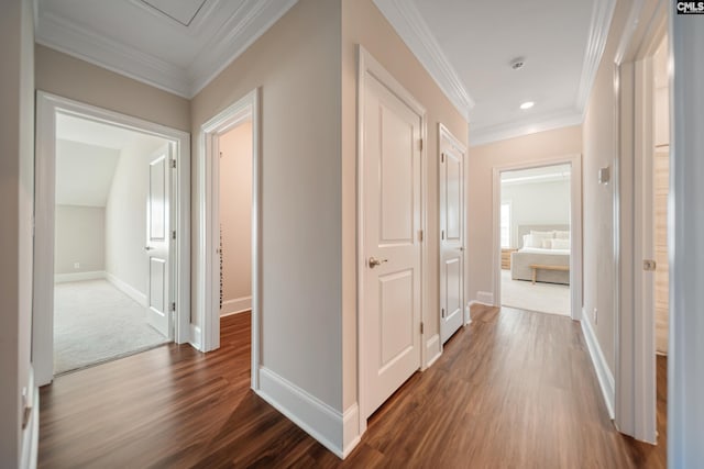 hallway with baseboards, ornamental molding, and dark wood-style flooring