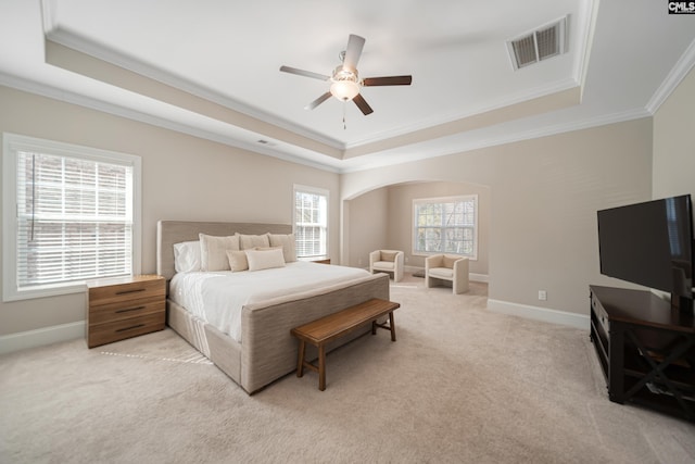 bedroom featuring a raised ceiling, light colored carpet, visible vents, and baseboards