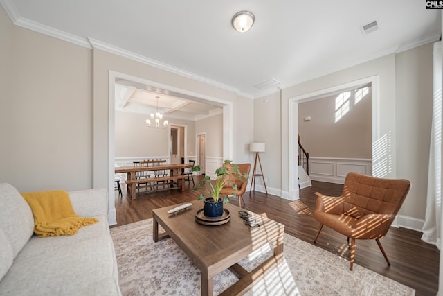 living room featuring wood finished floors, visible vents, coffered ceiling, and ornamental molding