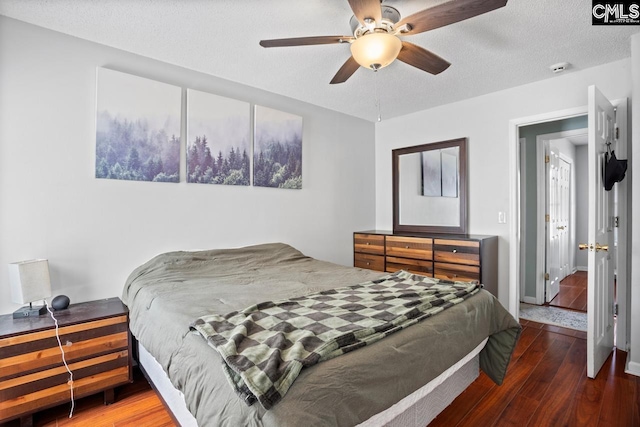 bedroom with a textured ceiling, wood finished floors, and ceiling fan