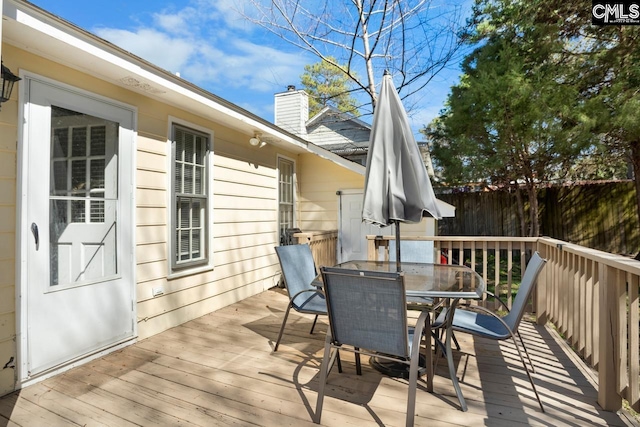 deck with outdoor dining area and fence