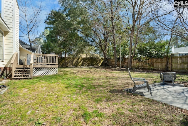 view of yard with a wooden deck, a fenced backyard, and a patio area