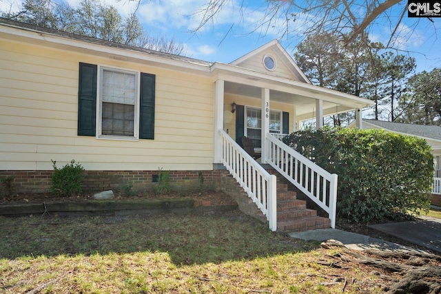 view of front facade featuring crawl space, covered porch, and stairs