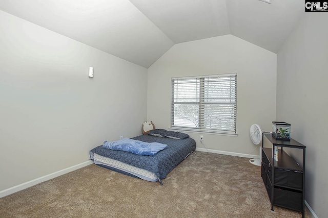 carpeted bedroom with lofted ceiling and baseboards