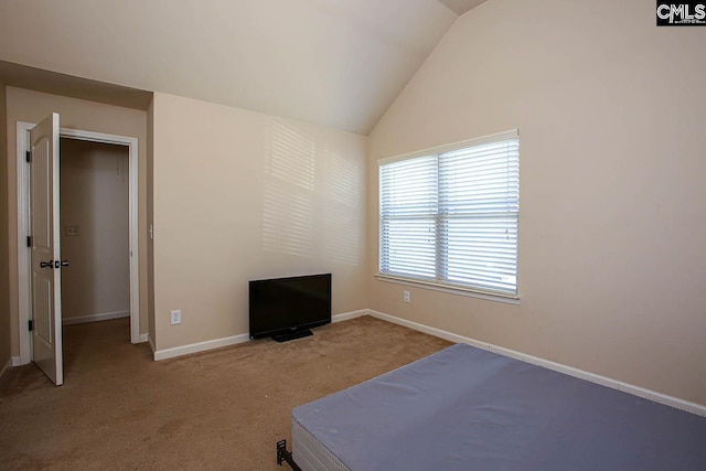 carpeted bedroom with baseboards and vaulted ceiling