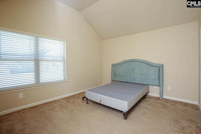 bedroom with lofted ceiling, carpet, and baseboards