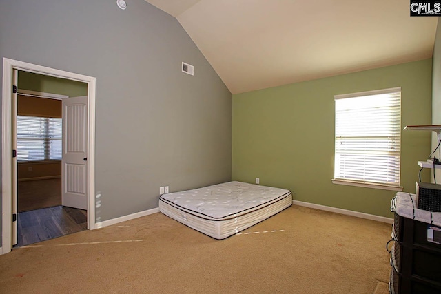 unfurnished bedroom with visible vents, carpet, baseboards, and vaulted ceiling