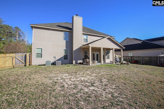 rear view of property featuring a lawn, a patio, a fenced backyard, cooling unit, and a chimney