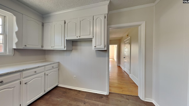 kitchen with a textured ceiling, dark wood-style floors, and white cabinetry