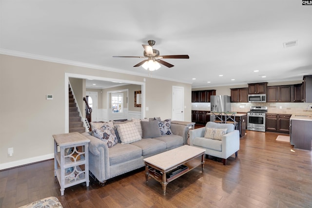 living room with visible vents, dark wood finished floors, a ceiling fan, and ornamental molding