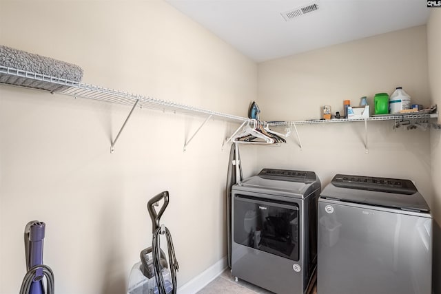 laundry room featuring visible vents, baseboards, light tile patterned floors, laundry area, and washer and dryer