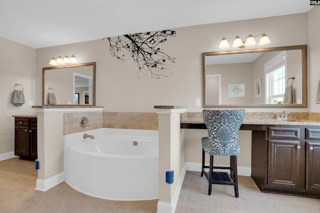 bathroom with vanity, tile patterned floors, a bath, and baseboards