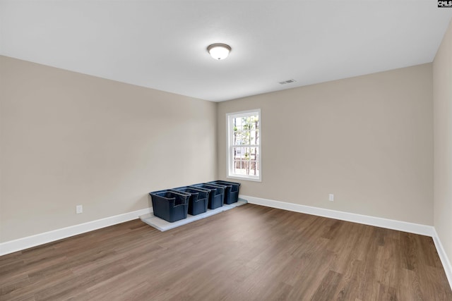 empty room with visible vents, baseboards, and wood finished floors