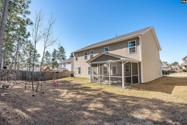 rear view of property with central AC unit, fence, a sunroom, and a lawn