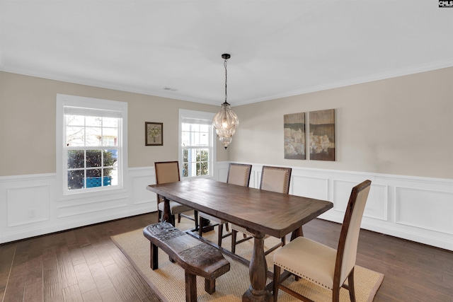 dining space with a chandelier, a wainscoted wall, crown molding, and dark wood-style flooring