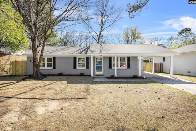 single story home featuring a carport, fence, brick siding, and driveway