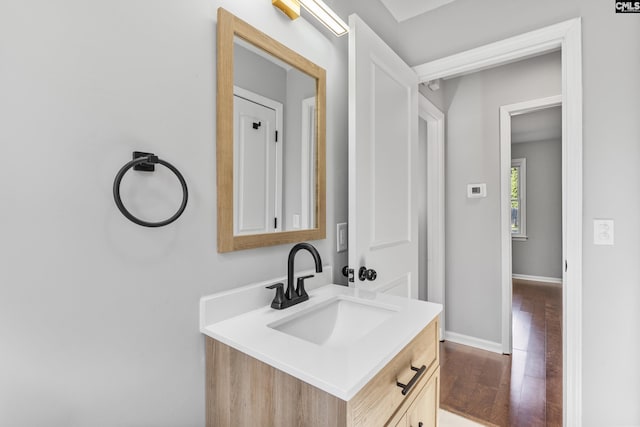 bathroom featuring vanity, wood finished floors, and baseboards